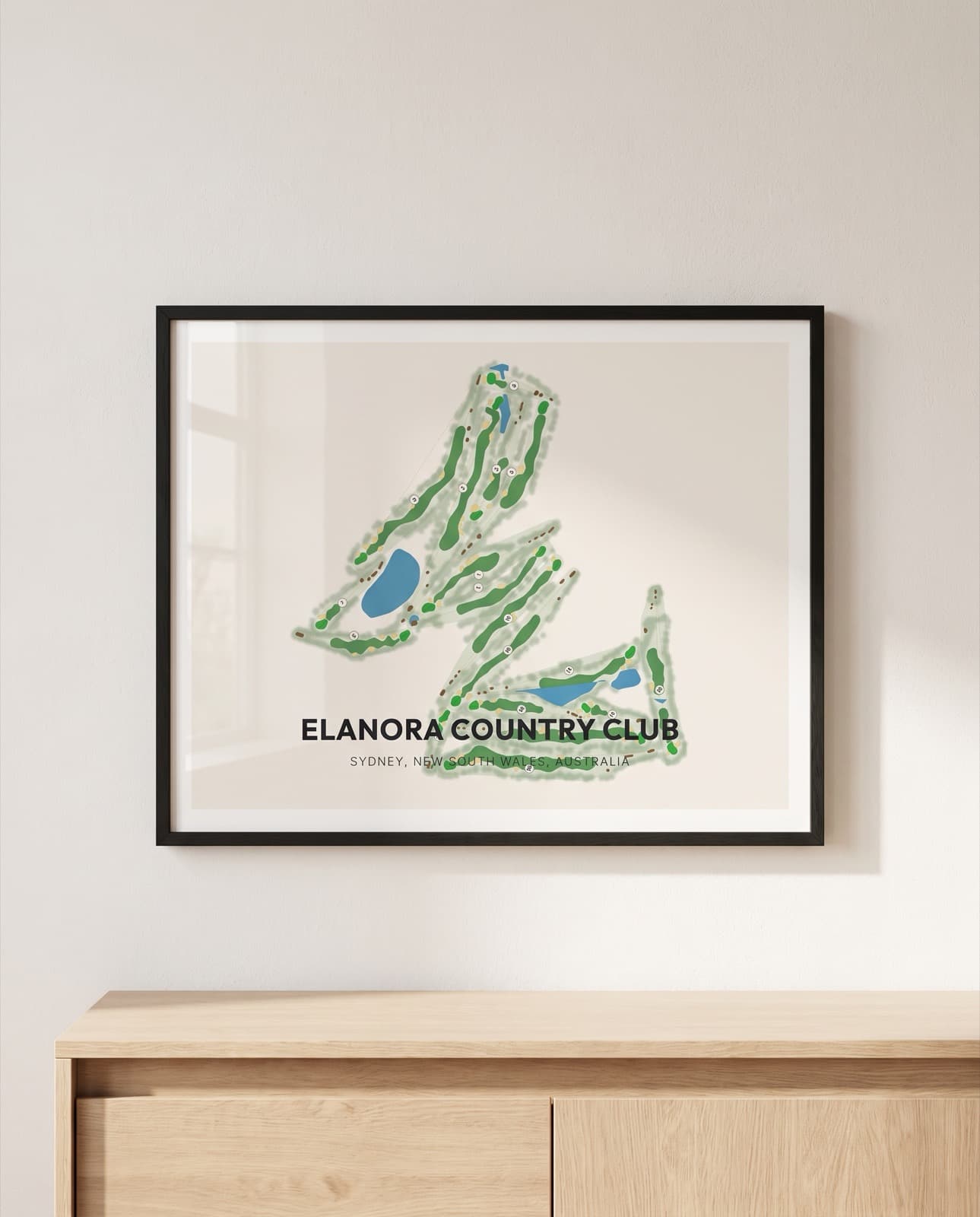 A framed course print standing above a sideboard